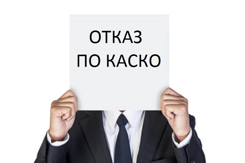 Мужчина в костюме держит перед собой лист с надписью отказ от КАСКО